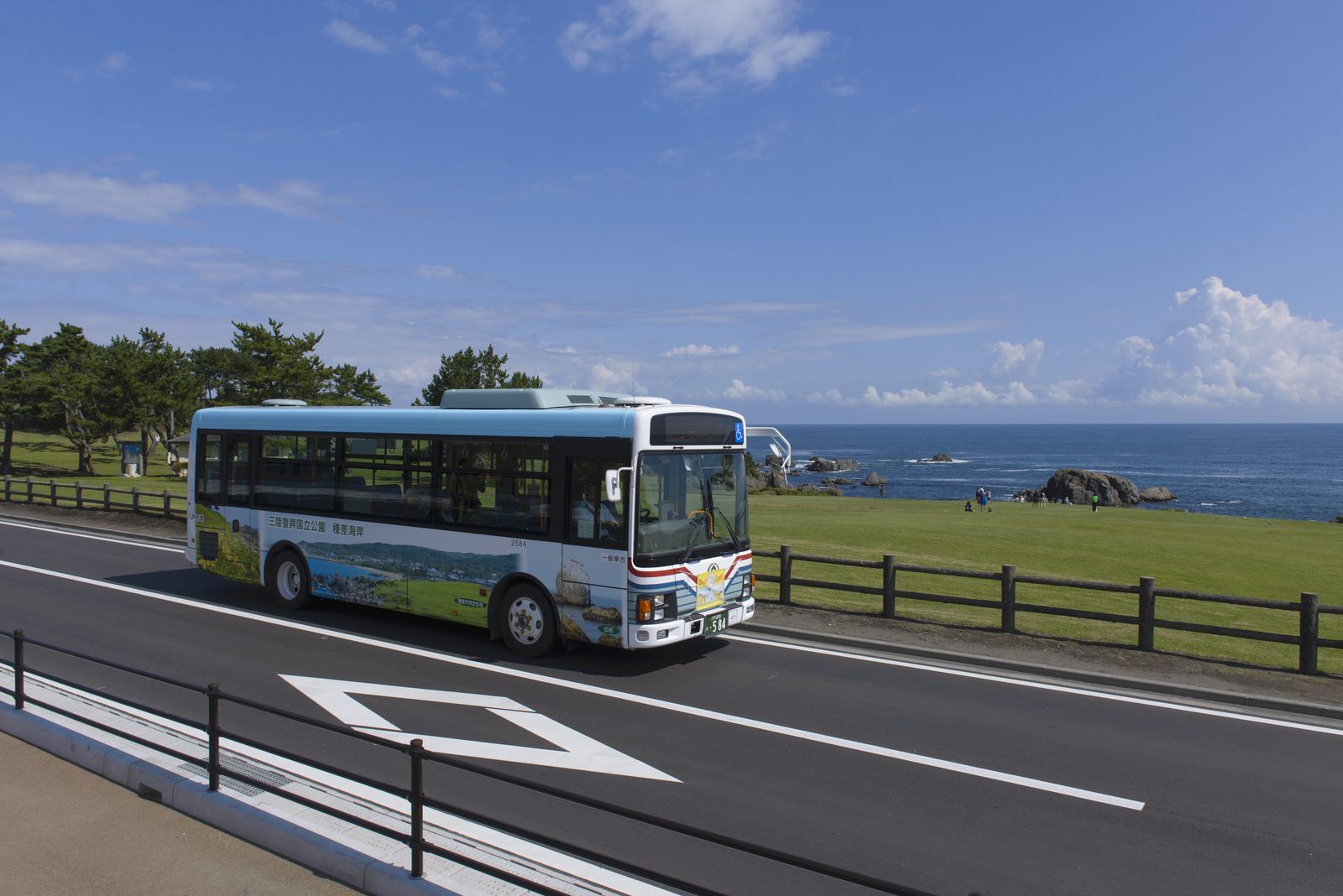 The Umineko-go coastal bus driving along the shore road past the Tanesashi lawn
