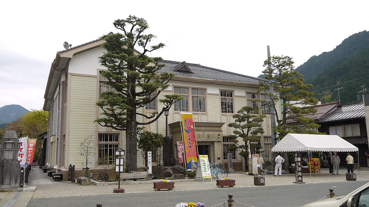 The wooden Western-style former Hachiman town hall, now a tourist information centre, with pines before its two-storey façade