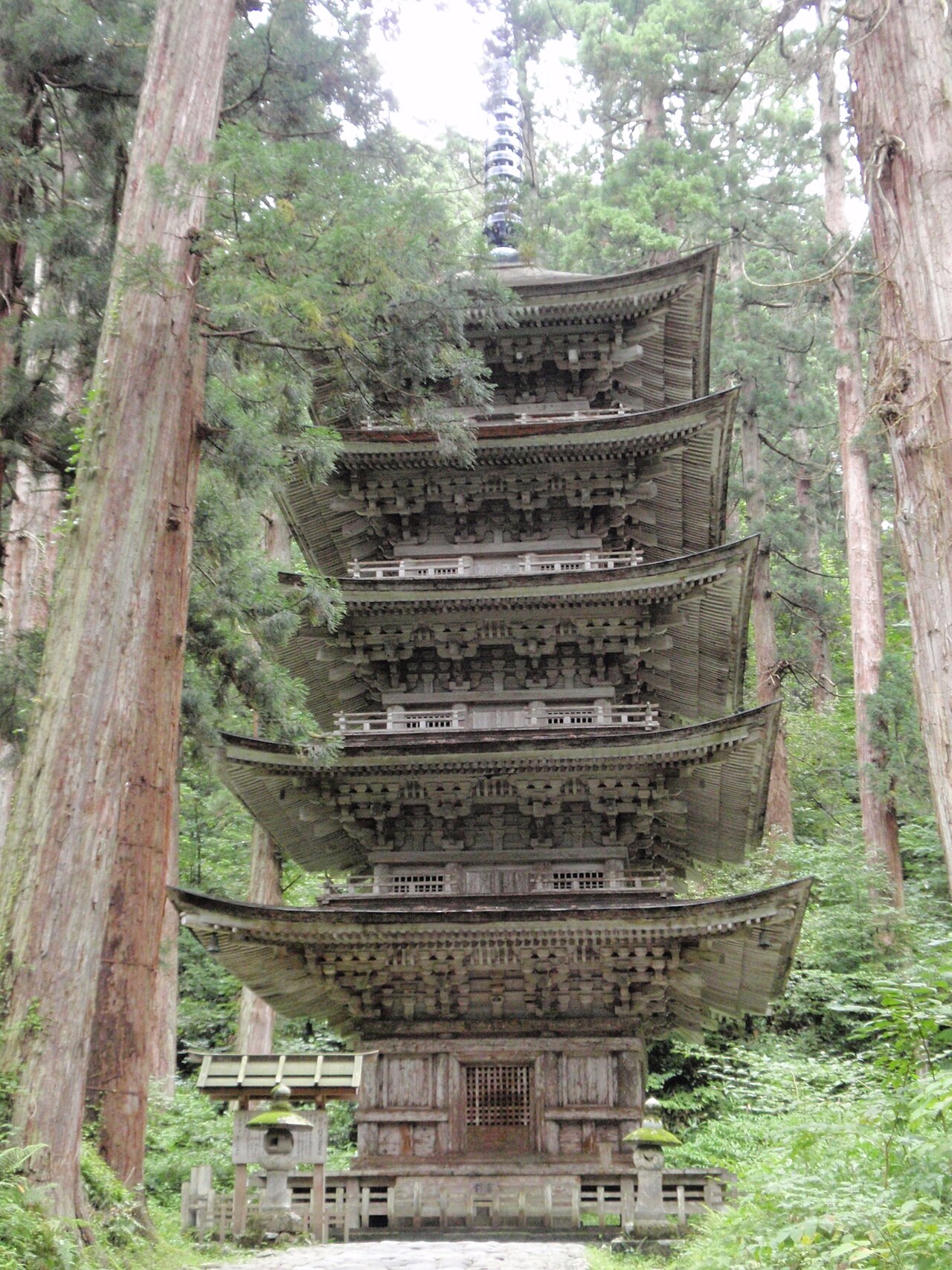 The five-story pagoda of Mount Haguro standing among the trunks of giant cedars