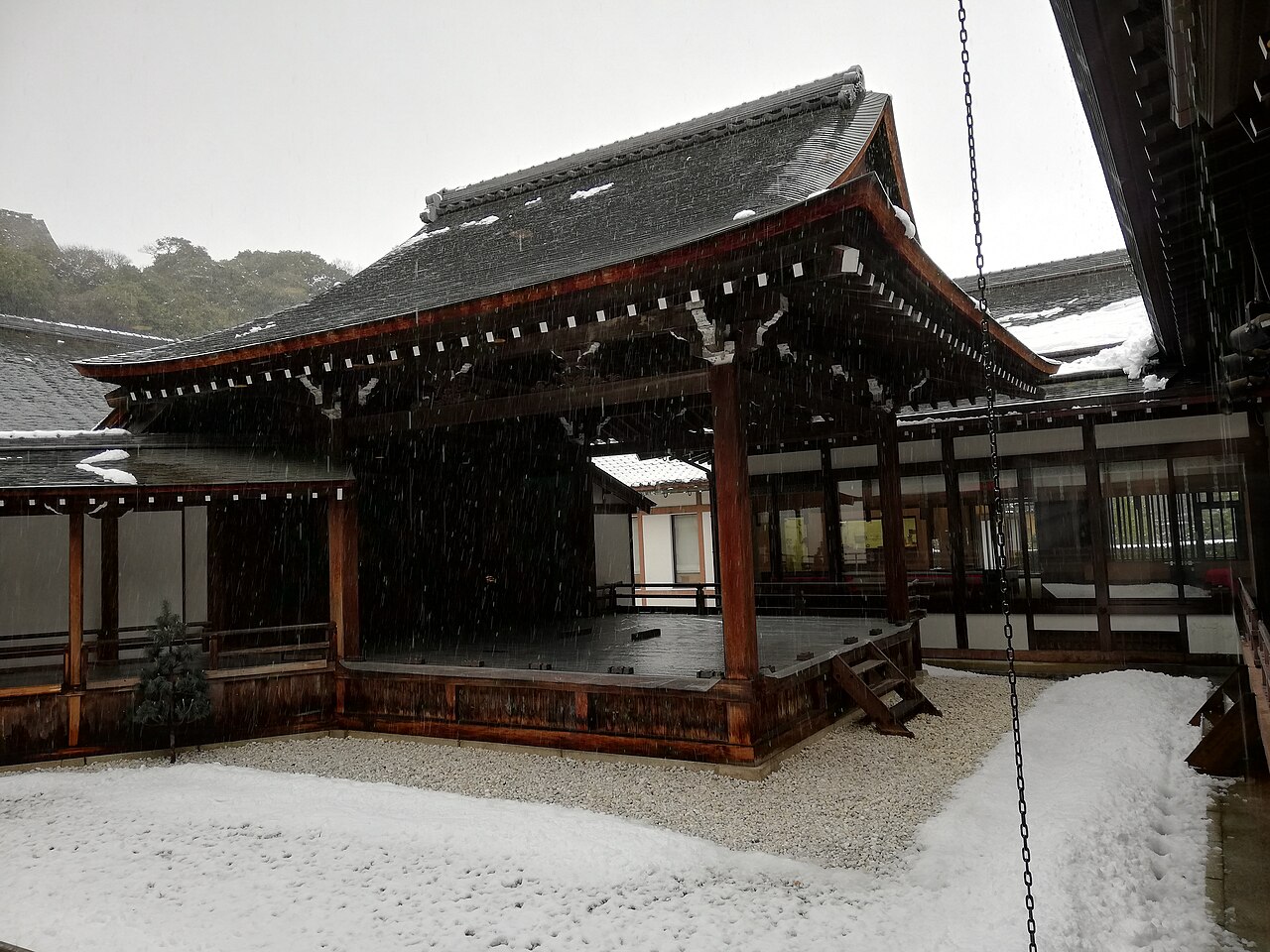 A wooden hall in the grounds of the Hikone Castle Museum under a dusting of snow.