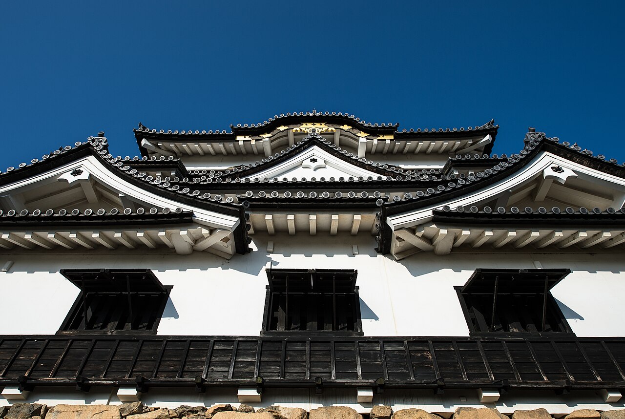 The keep of Hikone Castle, its white plaster walls and dark wooden eaves rising above the stone base.