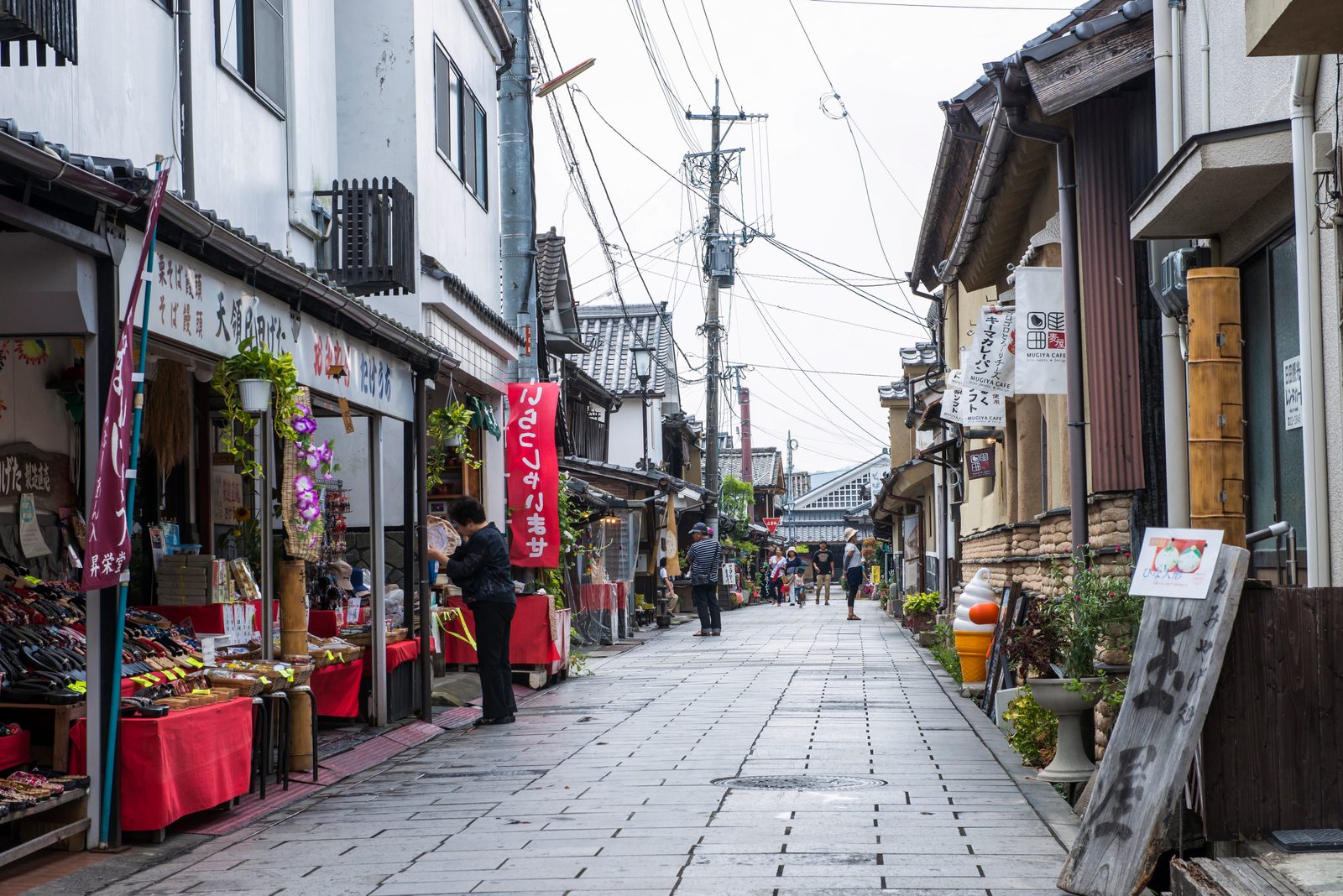A paved lane lined with old wooden merchant houses and shopfronts in the Mameda-machi district of Hita