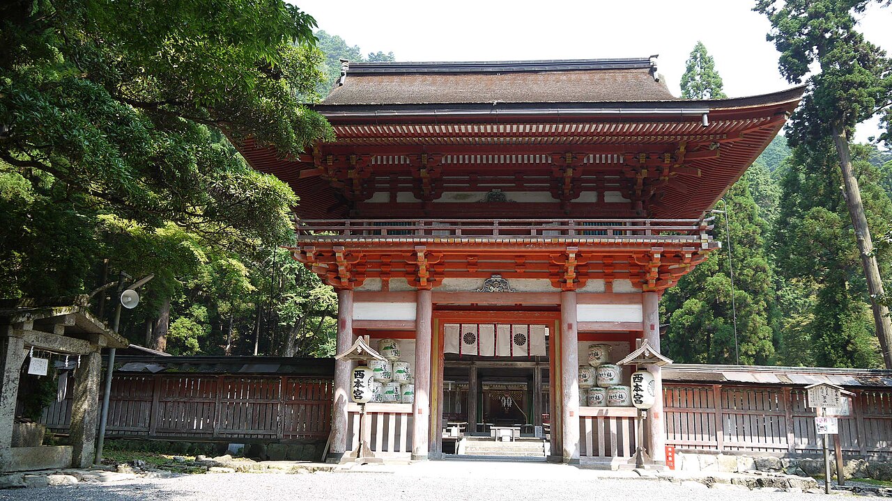 The vermilion two-storey romon gate of Hiyoshi Taisha, standing among tall cedars at the top of Sakamoto.