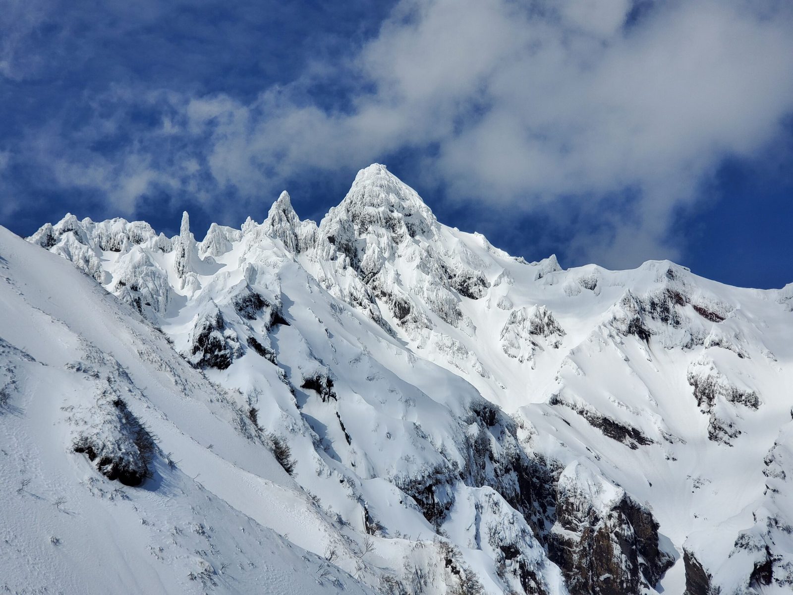 Snow-covered ridges near the summit of Mount Rishiri in winter under a blue sky