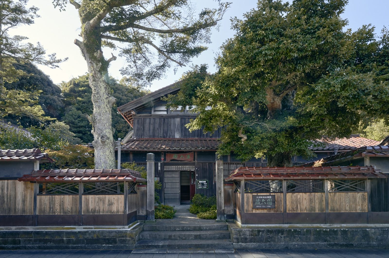Zorokuen, a former shipowner residence in Hashitate, behind its wooden fence and tall old trees