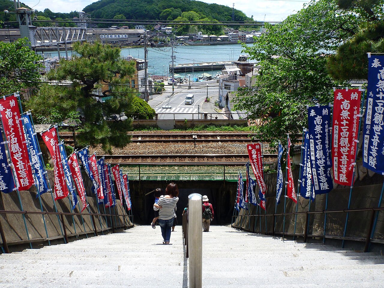 The stone approach steps of Jodoji temple in Onomichi, looking down over the railway line and the water of the channel.