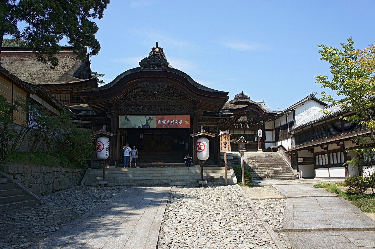 The Omote Shoin reception hall at Kotohira-gu, with two large crest lanterns standing in front of its curved gable.
