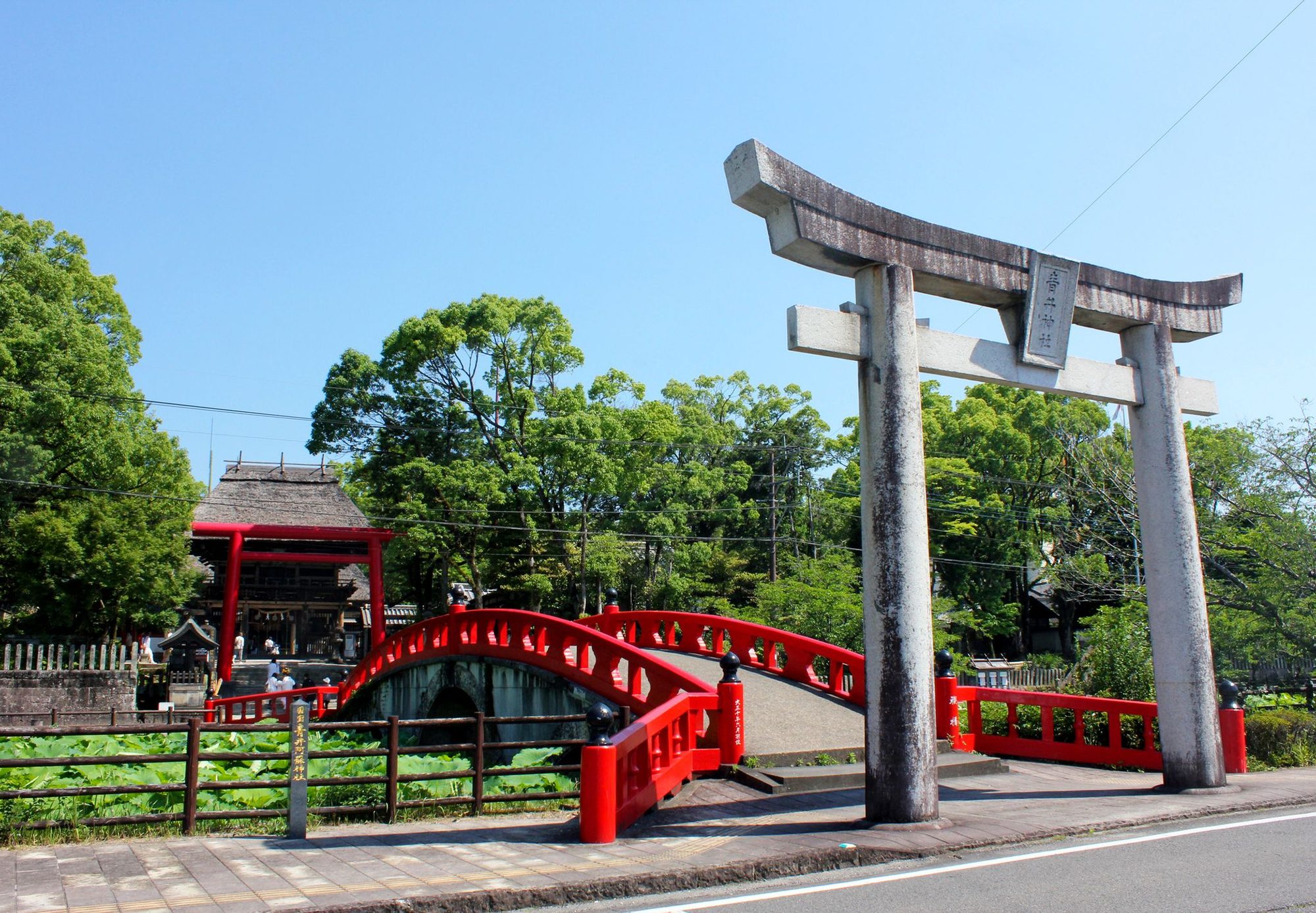 The vermilion Misogi Bridge arching over the pond in front of Aoi Aso Shrine in Hitoyoshi