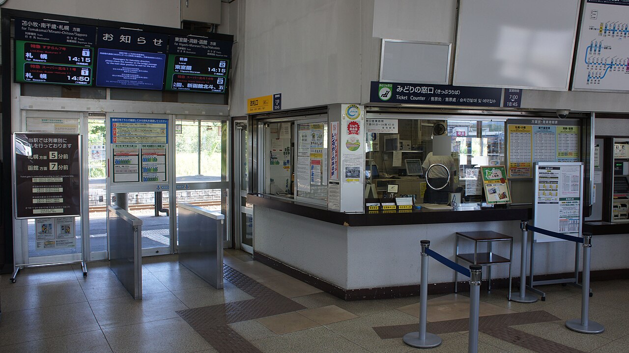 The small concourse of Noboribetsu Station, with the ticket gate, departure boards and a staffed ticket counter.