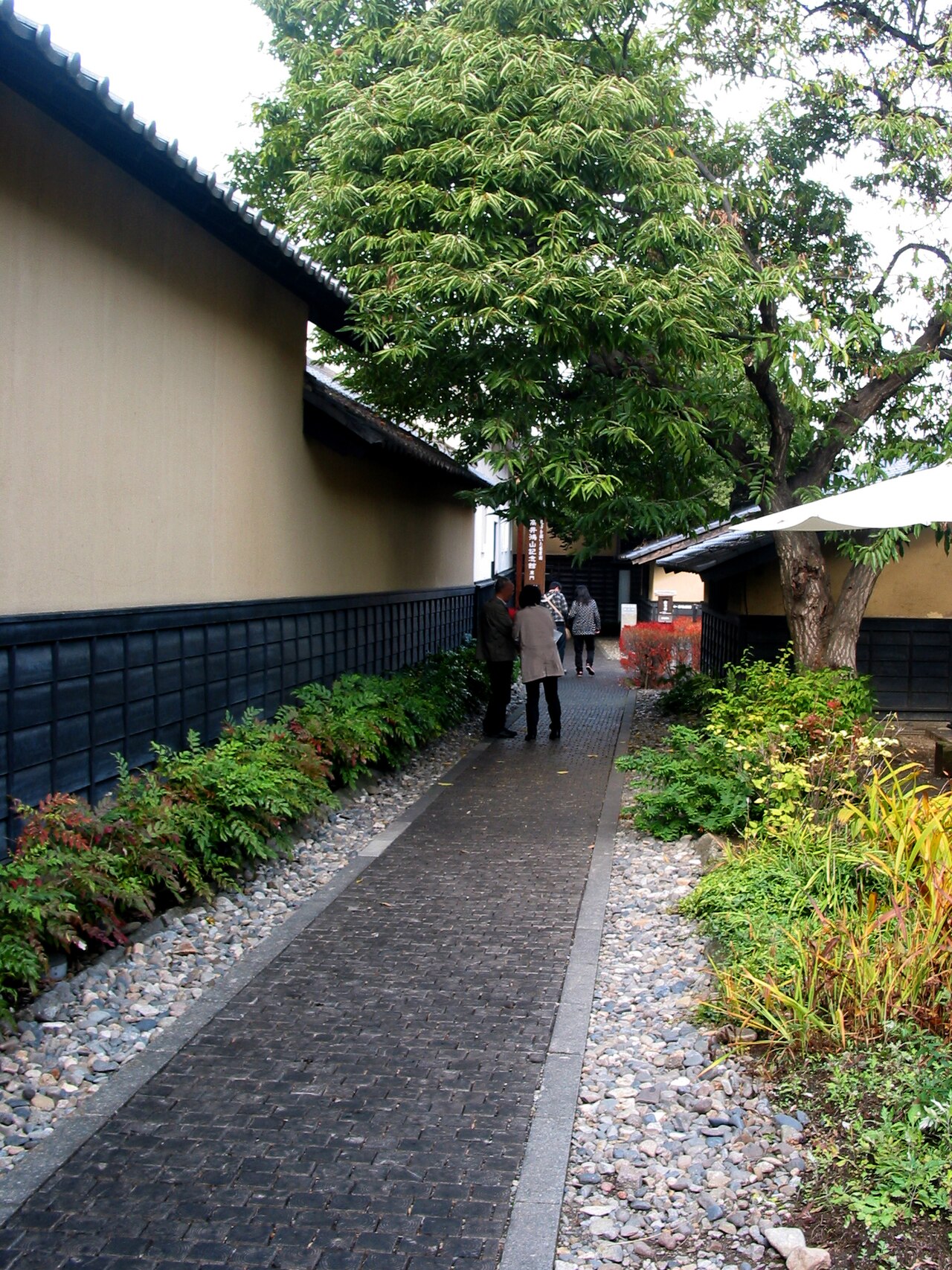Chestnut-wood paving on a lane in central Obuse, with white-walled storehouses to either side