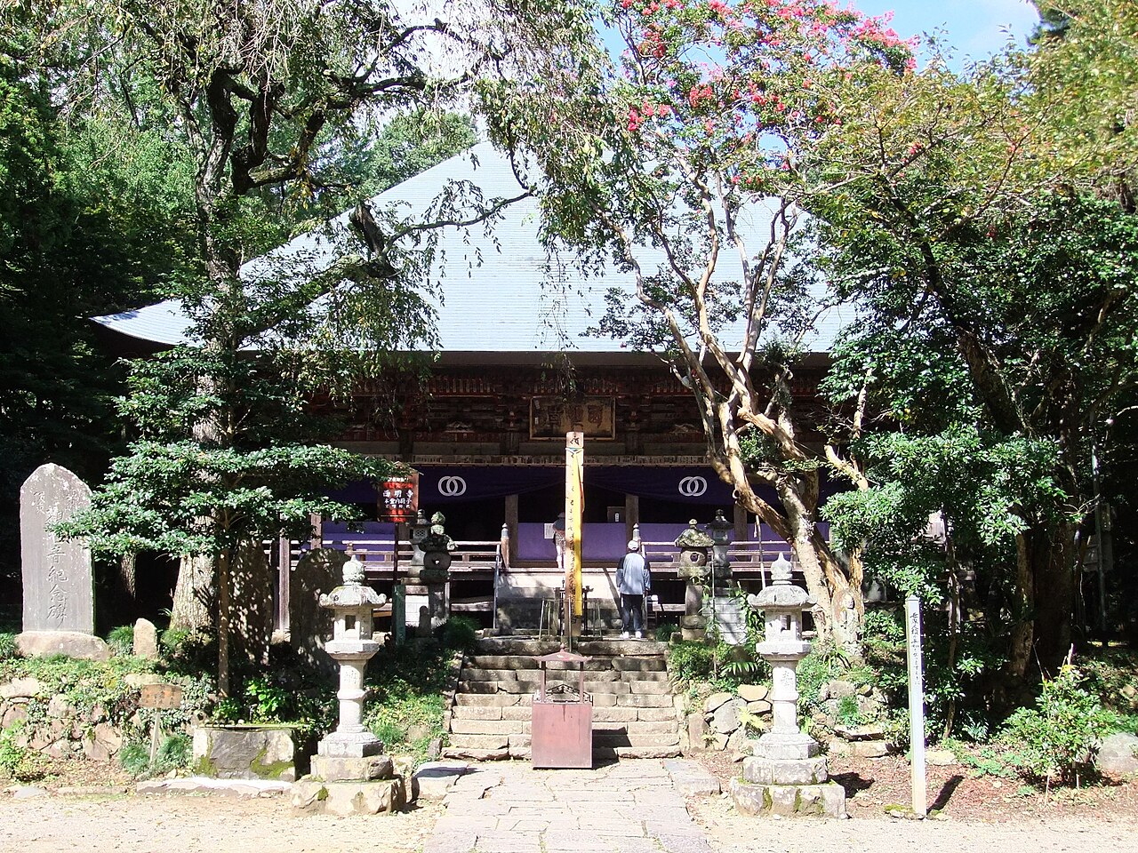 The main hall of Saimyo-ji in Mashiko, reached by stone steps between a pair of stone lanterns.