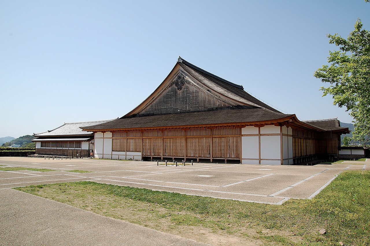 The rebuilt great hall of Sasayama Castle, a broad single-storey building with white walls under a shingled hip-and-gable roof.