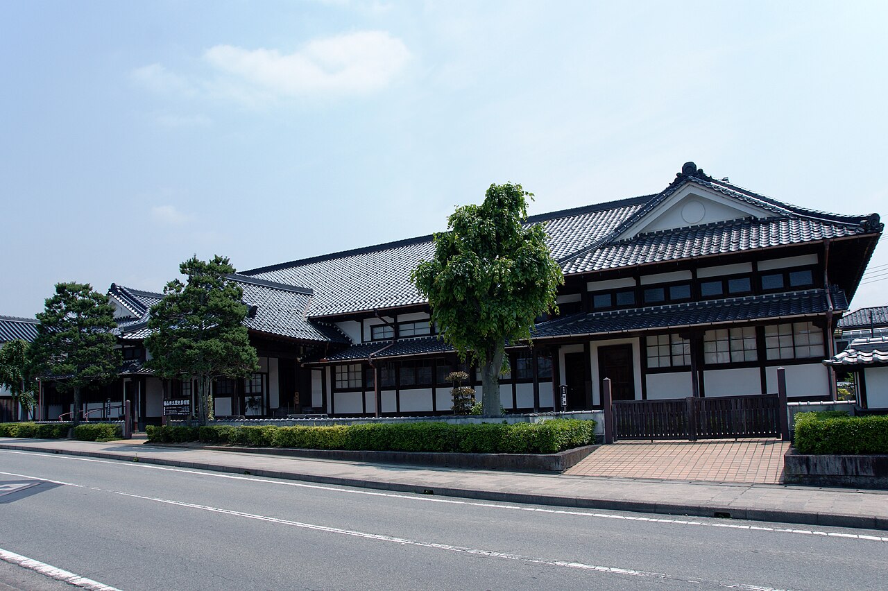 The Sasayama Historical Art Museum, a Meiji-era former courthouse with dark-and-white patterned walls and rows of Western-style windows.