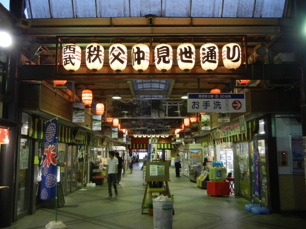 A covered shopping arcade with traditional-style shopfronts on Chichibu's Nakamise Street.