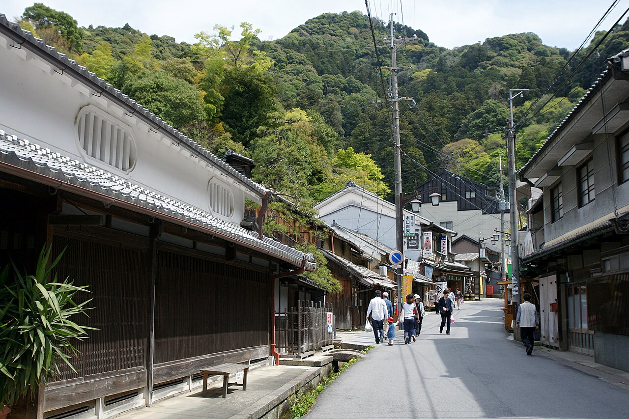 An old street of wooden merchant houses in the temple town near Hasedera, with green mountains behind