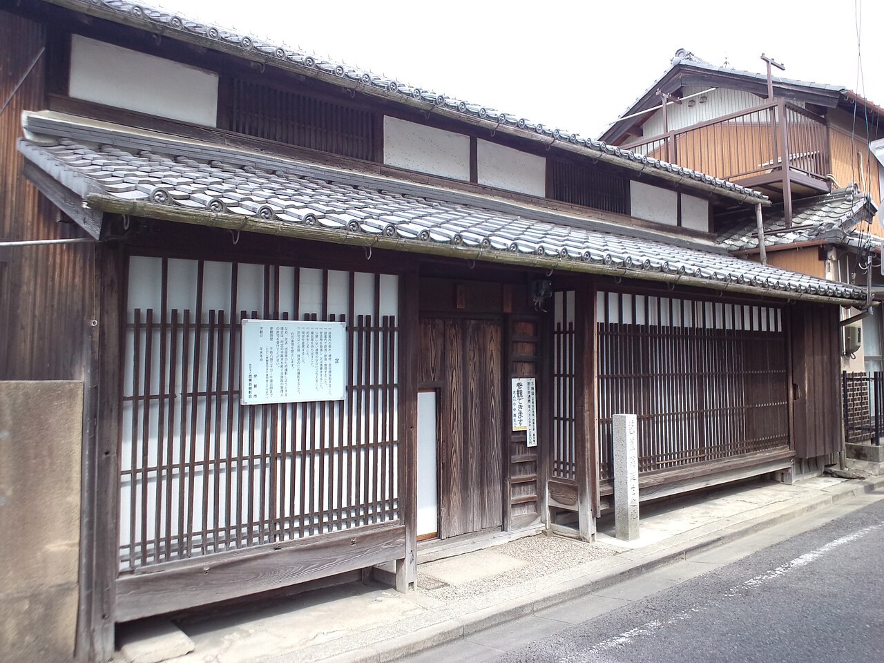 The front of Matsuo Basho's birthplace in Iga Ueno, a traditional townhouse with dark wooden lattice doors and a tiled roof along a quiet street