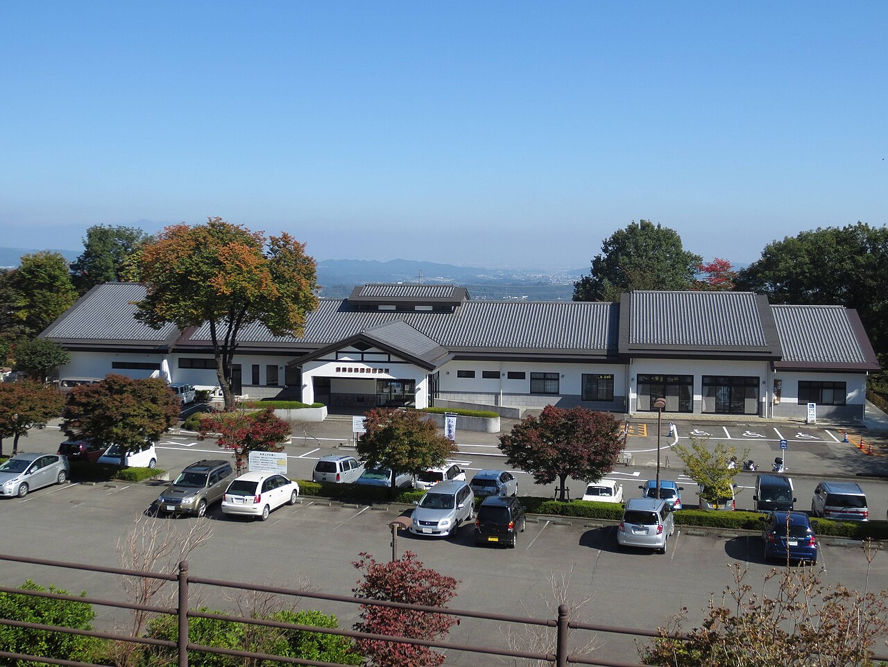 Momiji-no-yu, a foot of Mount Myogi hot-spring bathhouse with wooden eaves set against the autumn hillside