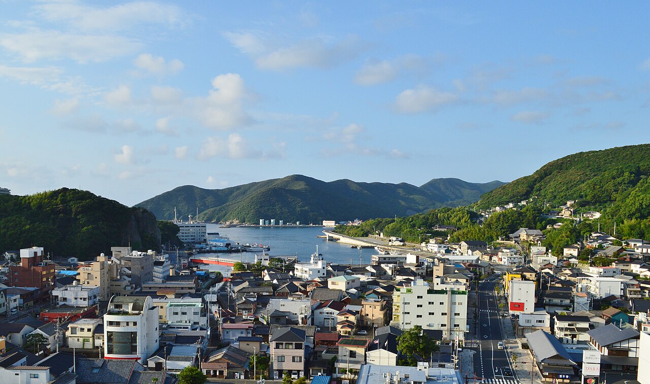 Izuhara town on Tsushima, low houses along a main street running down to the harbor with green hills beyond