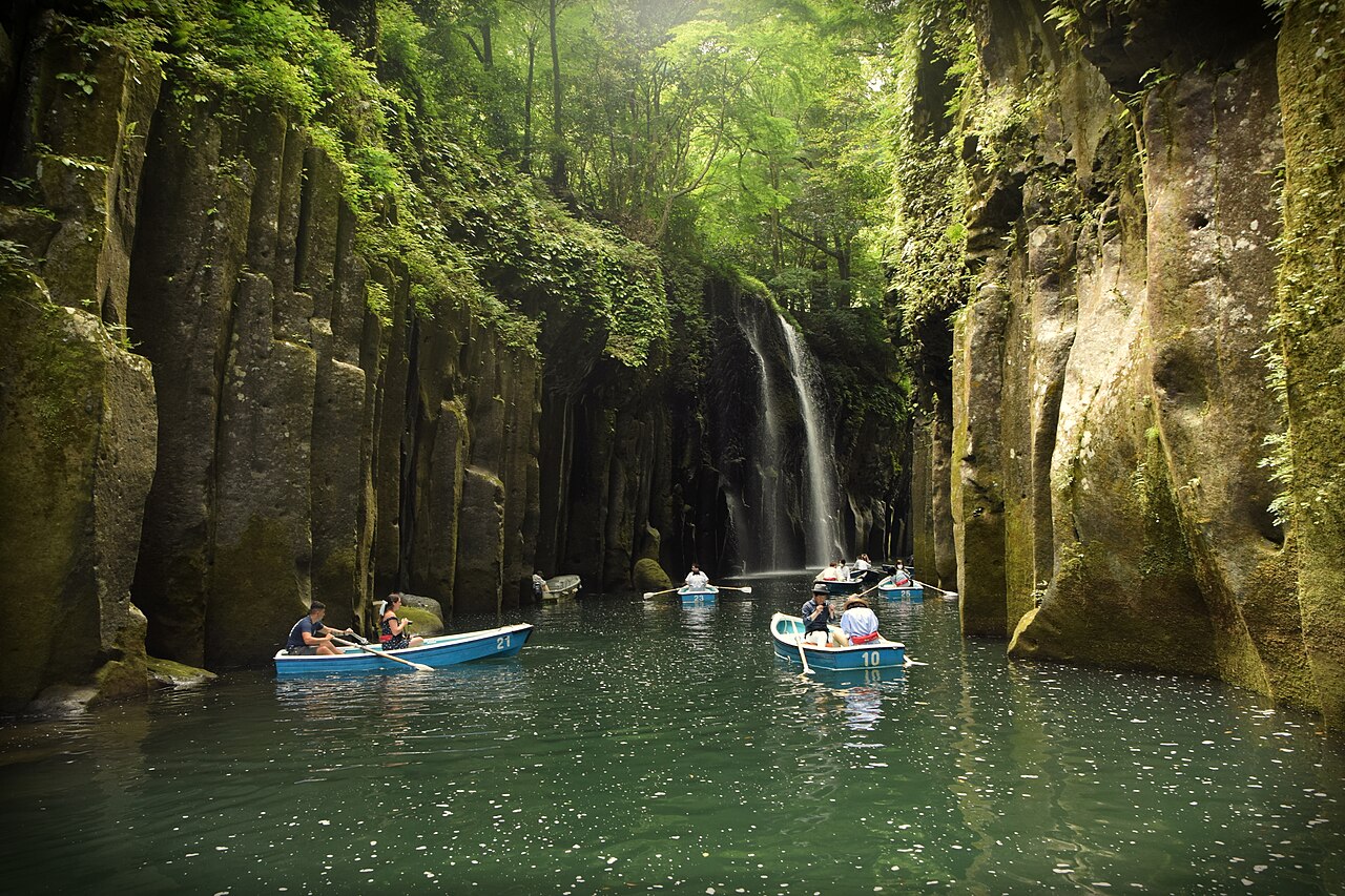 The narrow gorge at Takachiho, sheer rock walls above still green water.