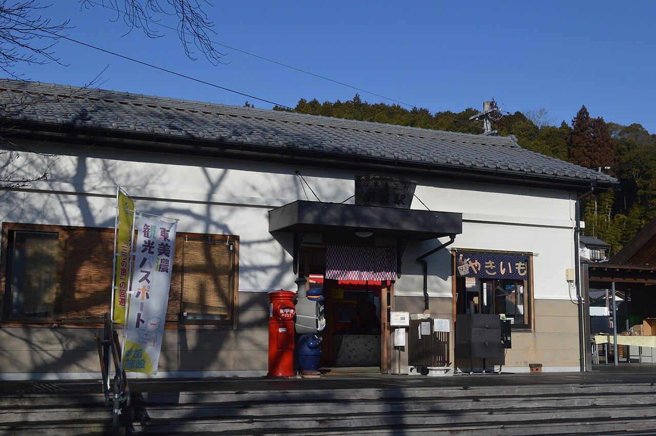 Akechi Station on the Akechi Railway, a low tiled-roof building with a red cylindrical postbox by the entrance