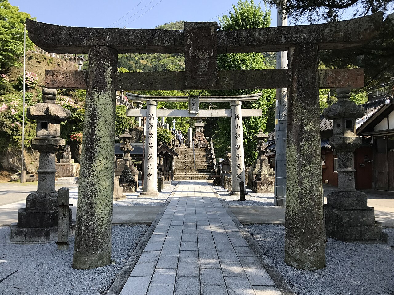Stone steps and stone torii gates lining the approach to Sueyama Shrine in Arita, with a smaller gate and stone lanterns at the top