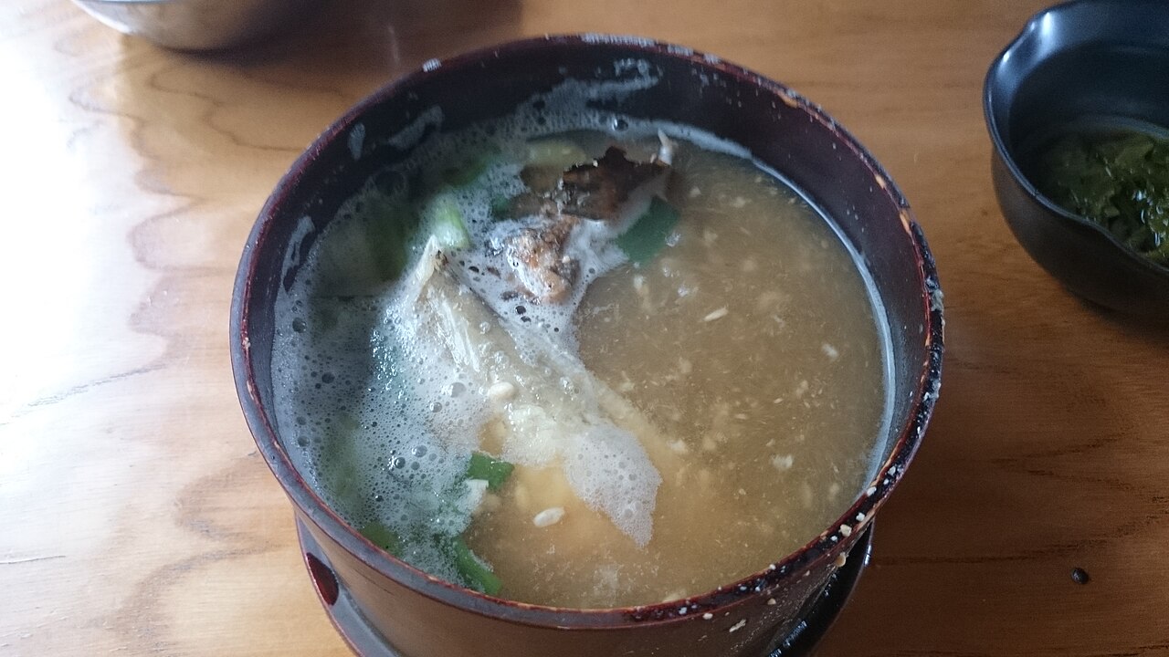Wappa-ni in a lacquered bowl, with grilled fish and sliced green onion.