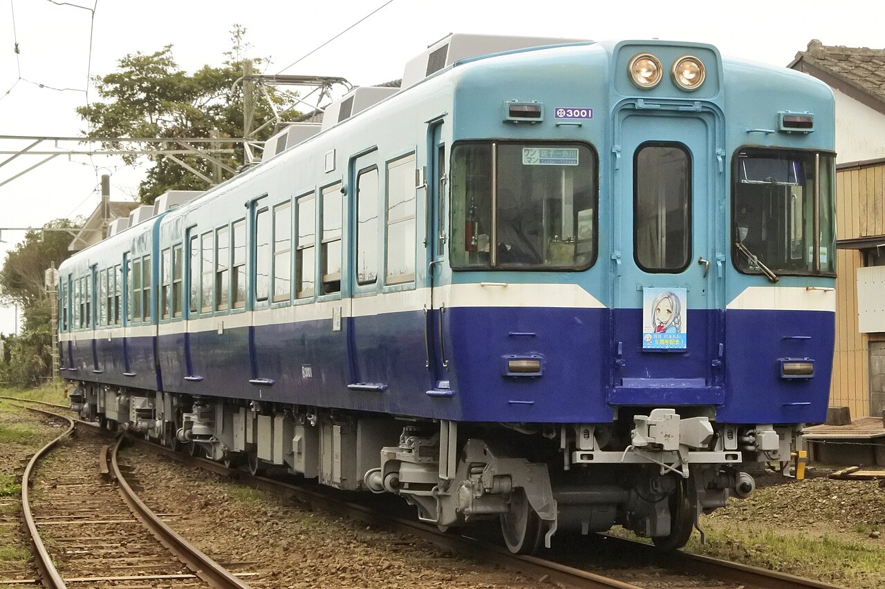 A blue and white Choshi Electric Railway train waiting at a small station platform