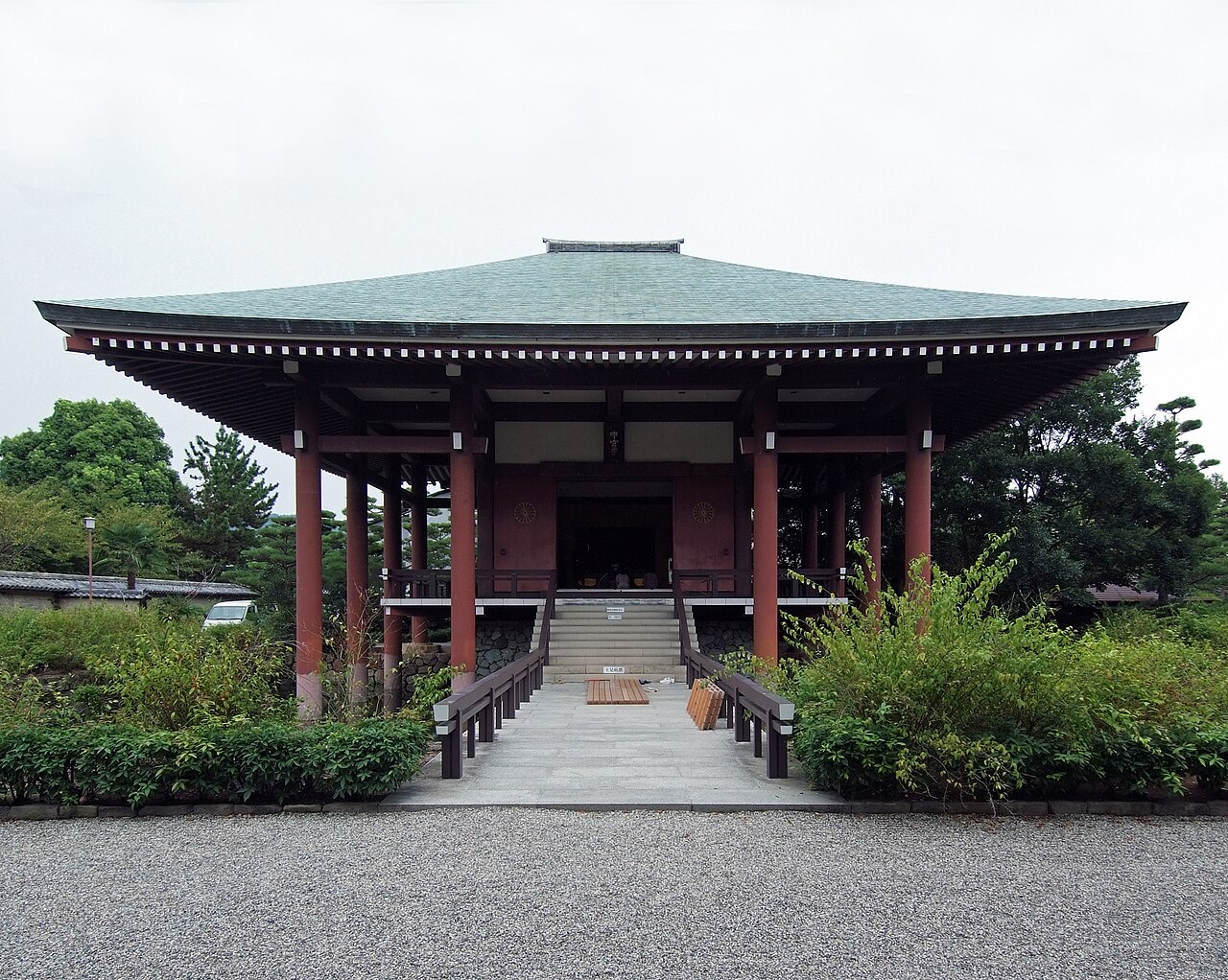 Chuguji's main hall, with red pillars under a broad green roof, at the top of a short stone path lined with shrubs