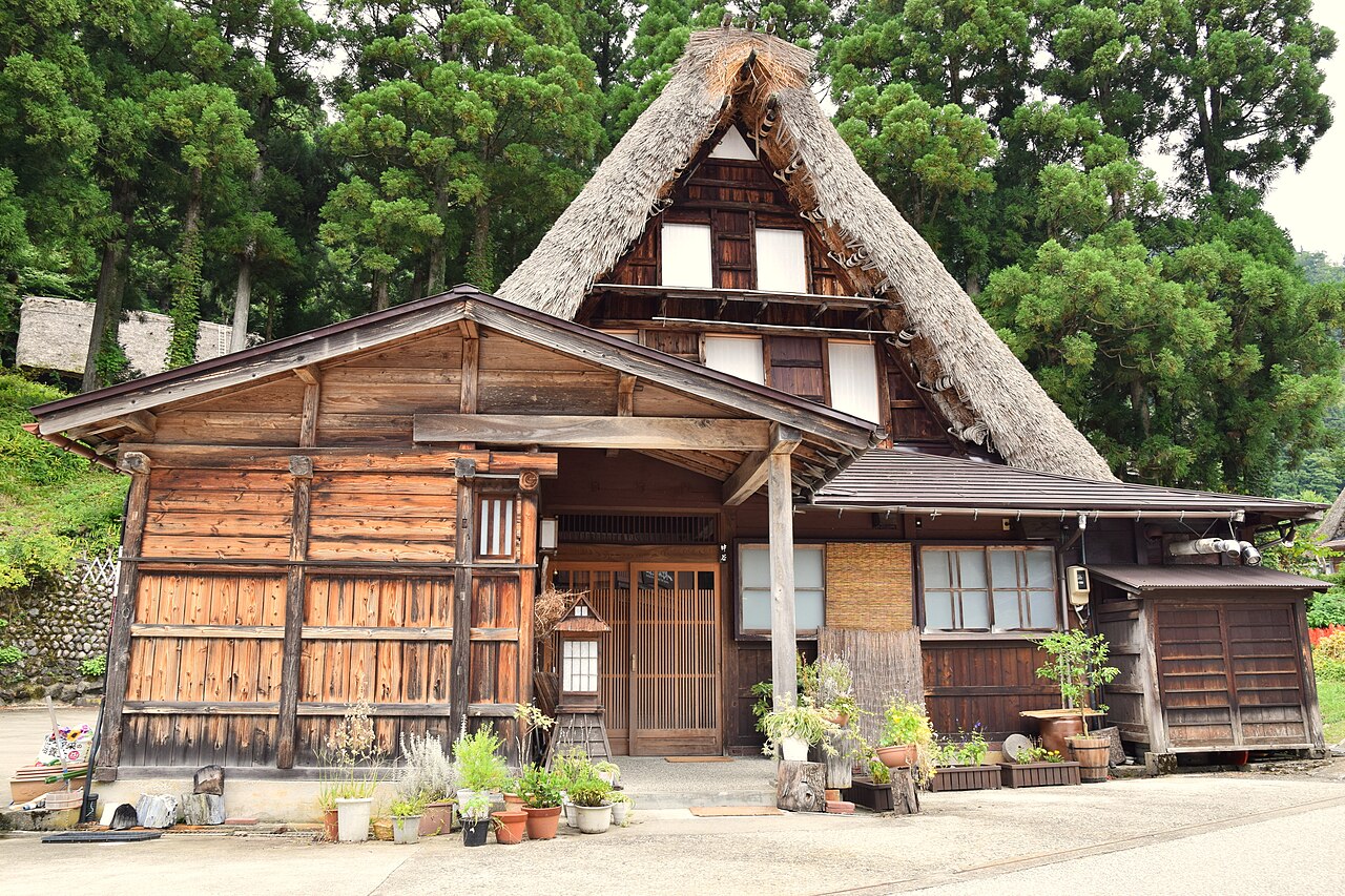 A gassho-zukuri farmhouse in Gokayama with potted plants along its stone entrance