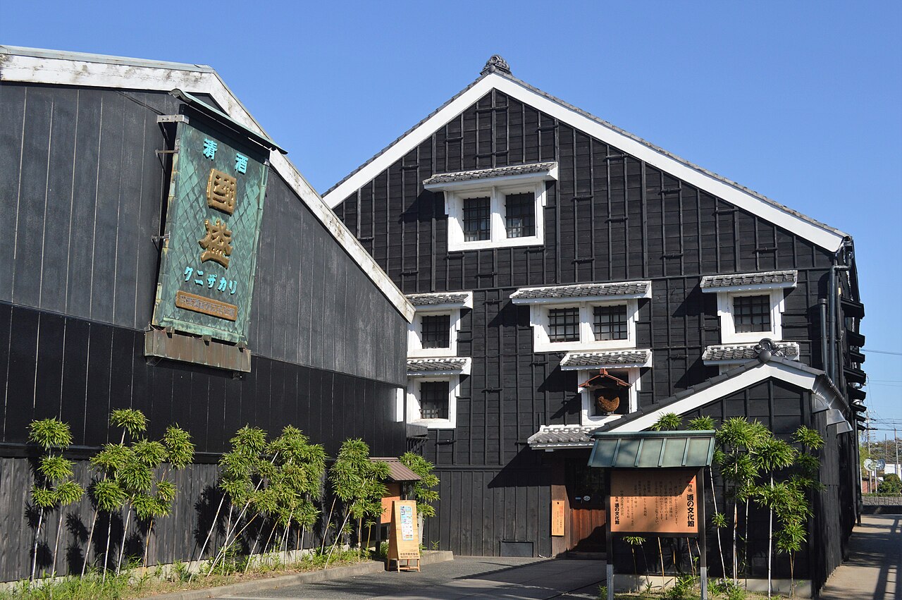 The black storehouse front of the Kunizakari Sake Cultural Museum with its wooden sign