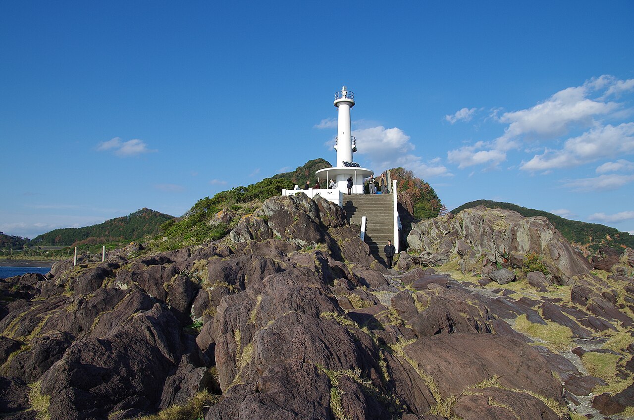 White lighthouse on the rocks at Nagasakibana with steps leading up and a few visitors