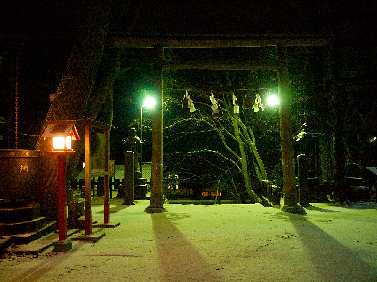 A torii gate at Ikaho Shrine at night in the snow.