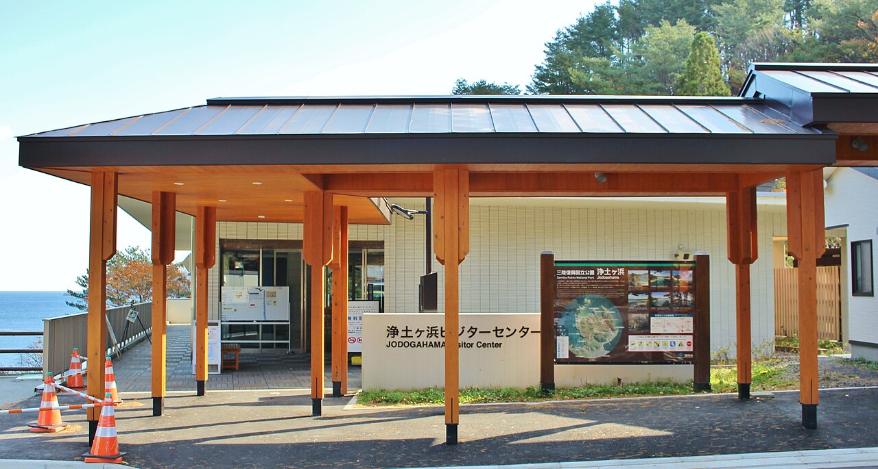 The entrance of the Jodogahama Visitor Center, a low building with wooden pillars and a sign board