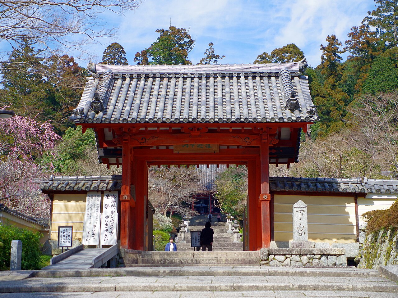 The red-pillared gate of Kanshinji with stone steps rising into the trees beyond