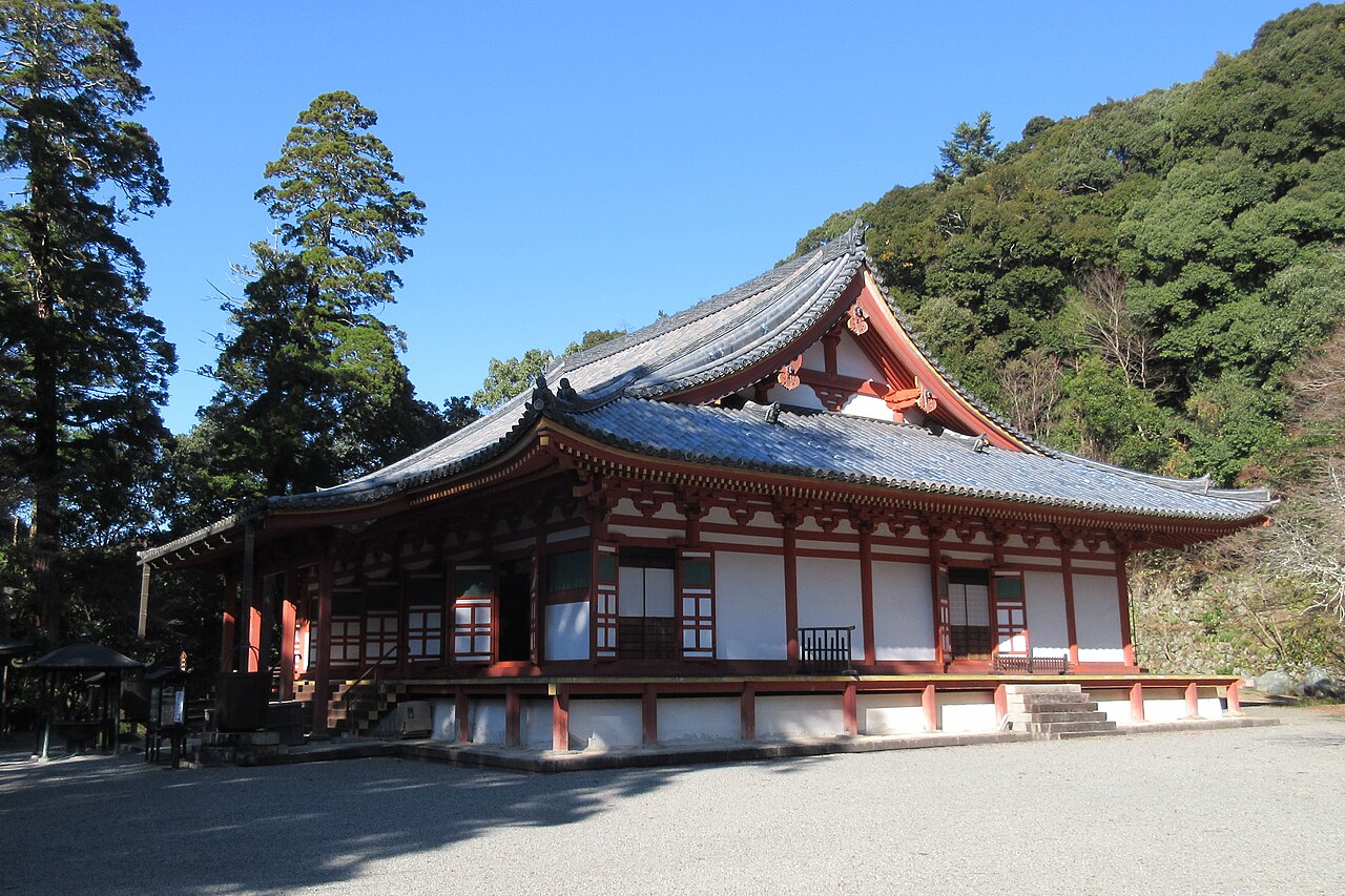 The red-and-white Kondo main hall of Kanshinji with a sweeping tiled roof, seen across the gravel courtyard
