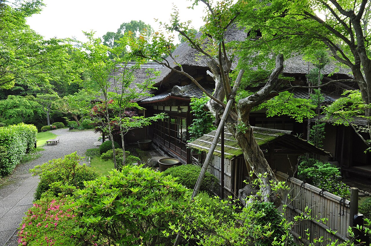 Shunpu Banri-so, a relocated thatched-roof farmhouse villa set among trees and clipped shrubs on the grounds of the Kasama Nichido Museum of Art.