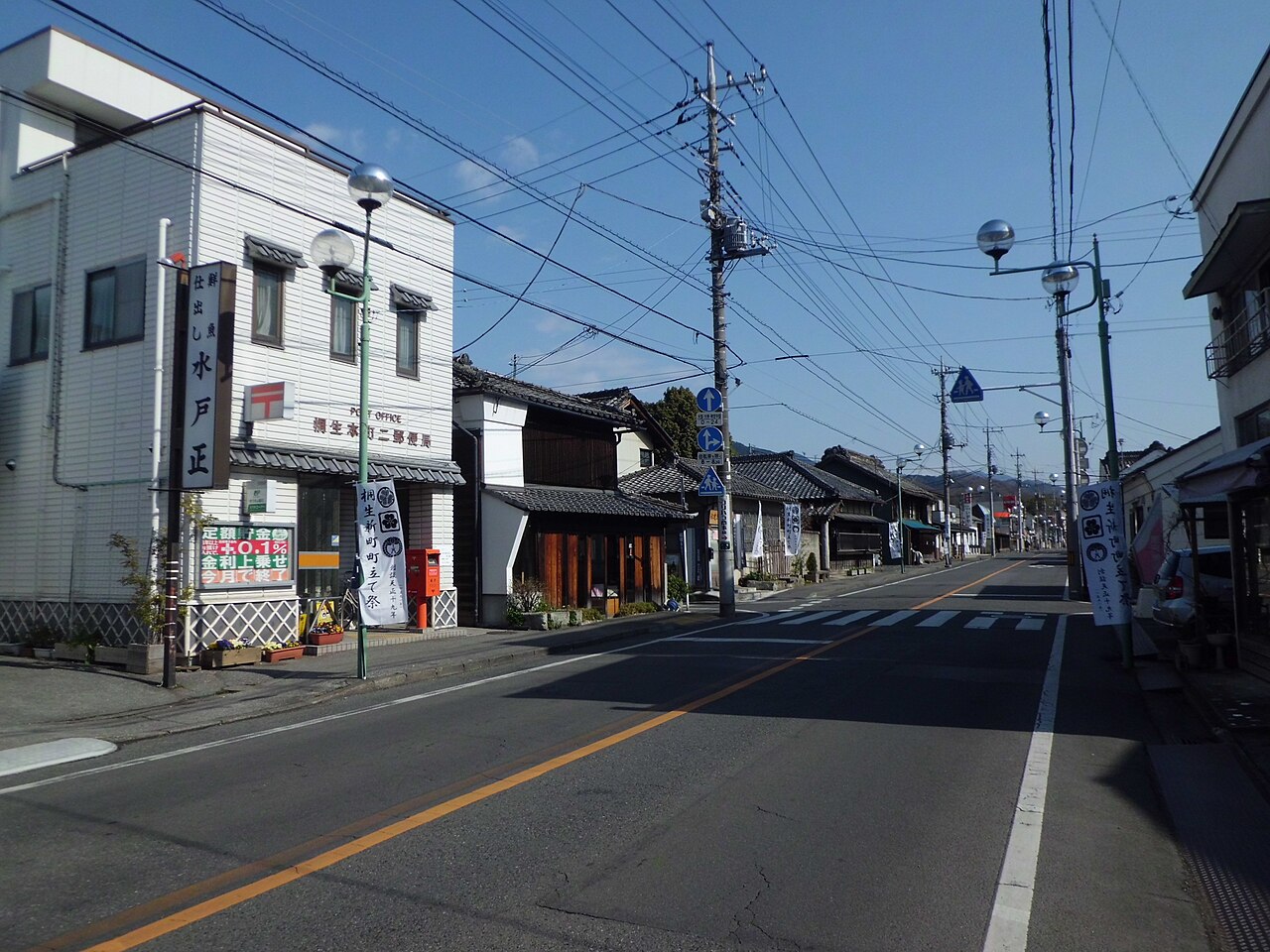 Honcho 2-chome in Kiryu, where old tiled-roof shopfronts line the street beyond a corner post office.