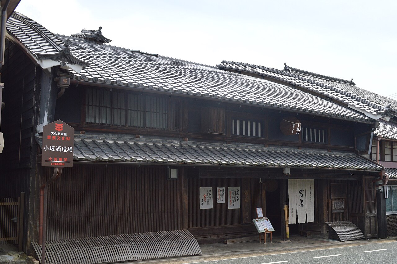 Exterior of the Kosaka family residence and former sake brewery, a two-story timber townhouse with a curved roof and udatsu firewalls.