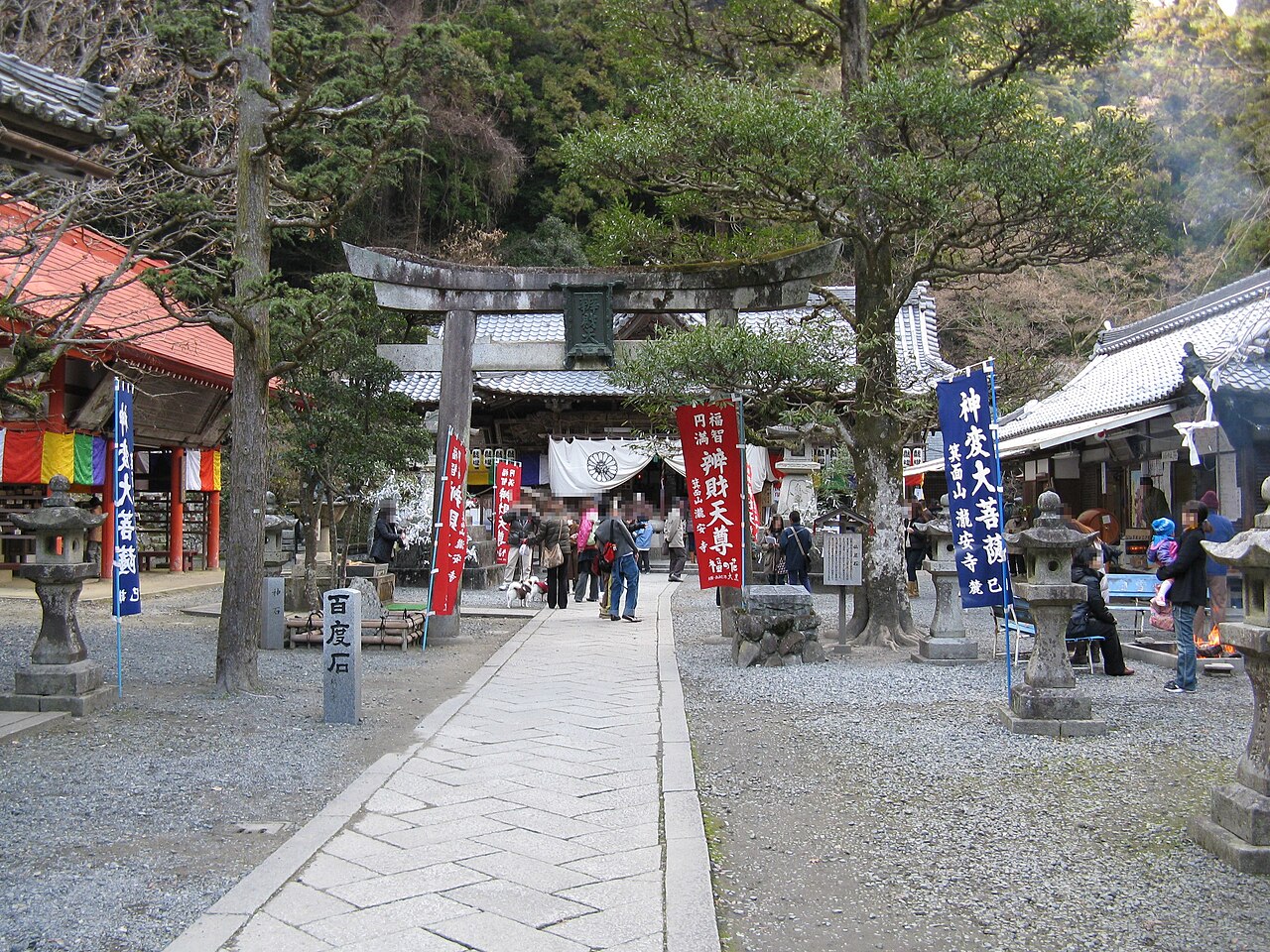 Stone torii gateway and prayer banners at the entrance to Ryuanji temple in Minoh Park, Osaka.