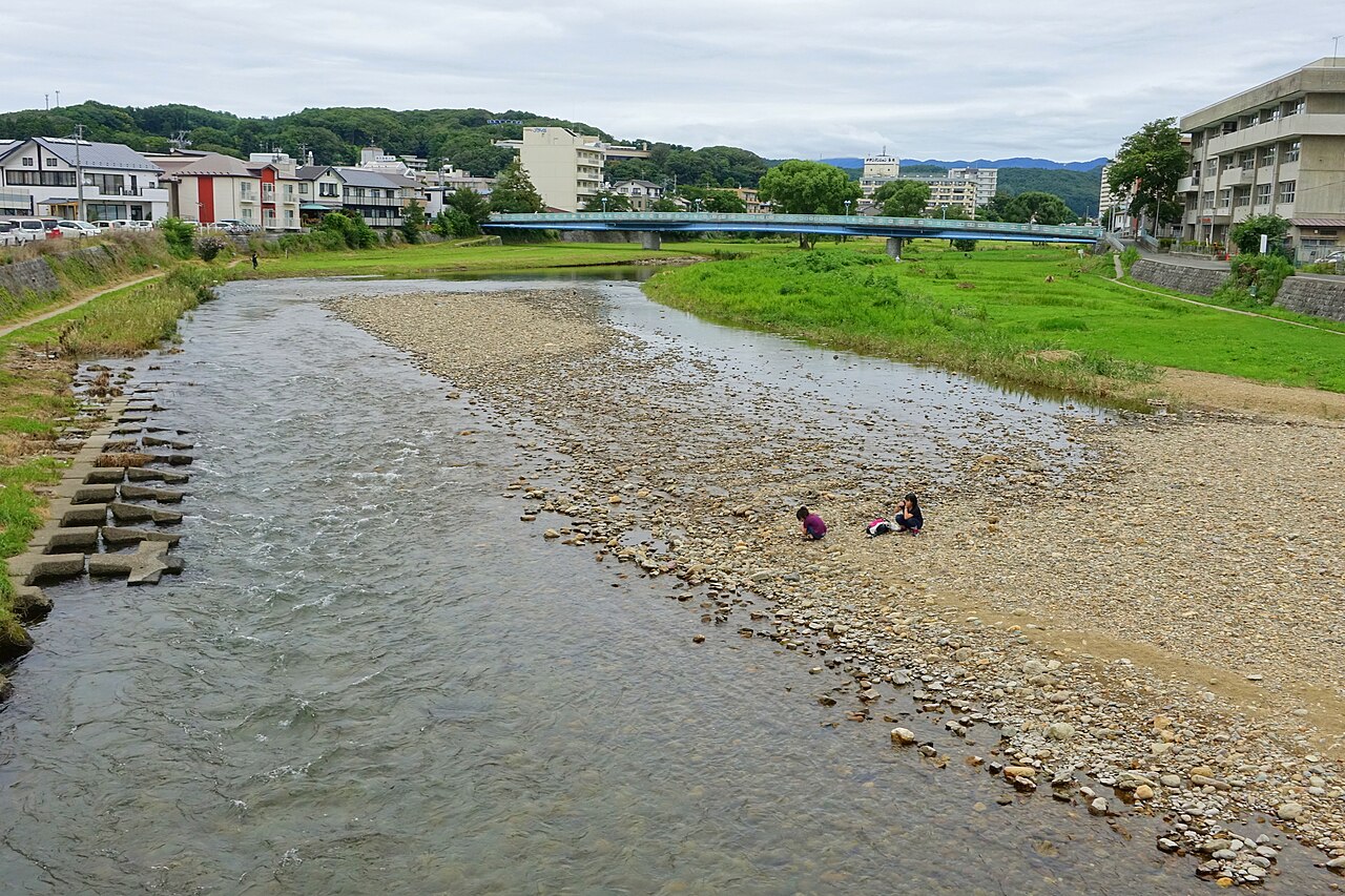The Nakatsu River in Morioka with a gravel bank, grassy embankments and a blue bridge in the distance.