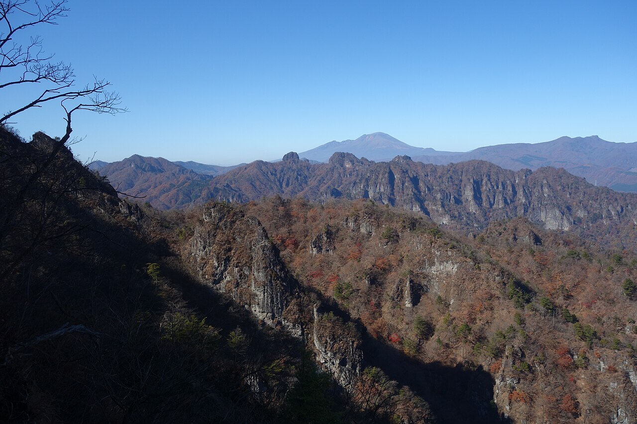 Jagged rock ridgeline of Mount Myogi and Ura-Myogi seen from near Bibiri-iwa, with Mount Asama visible in the distance