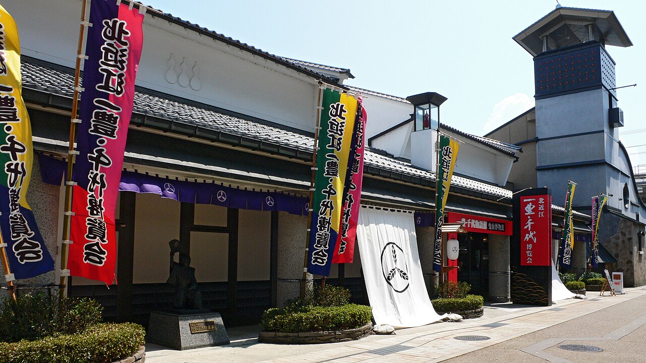 The exterior of the Hikiyama Museum, with white walls, a tiled roof and a row of colourful banners