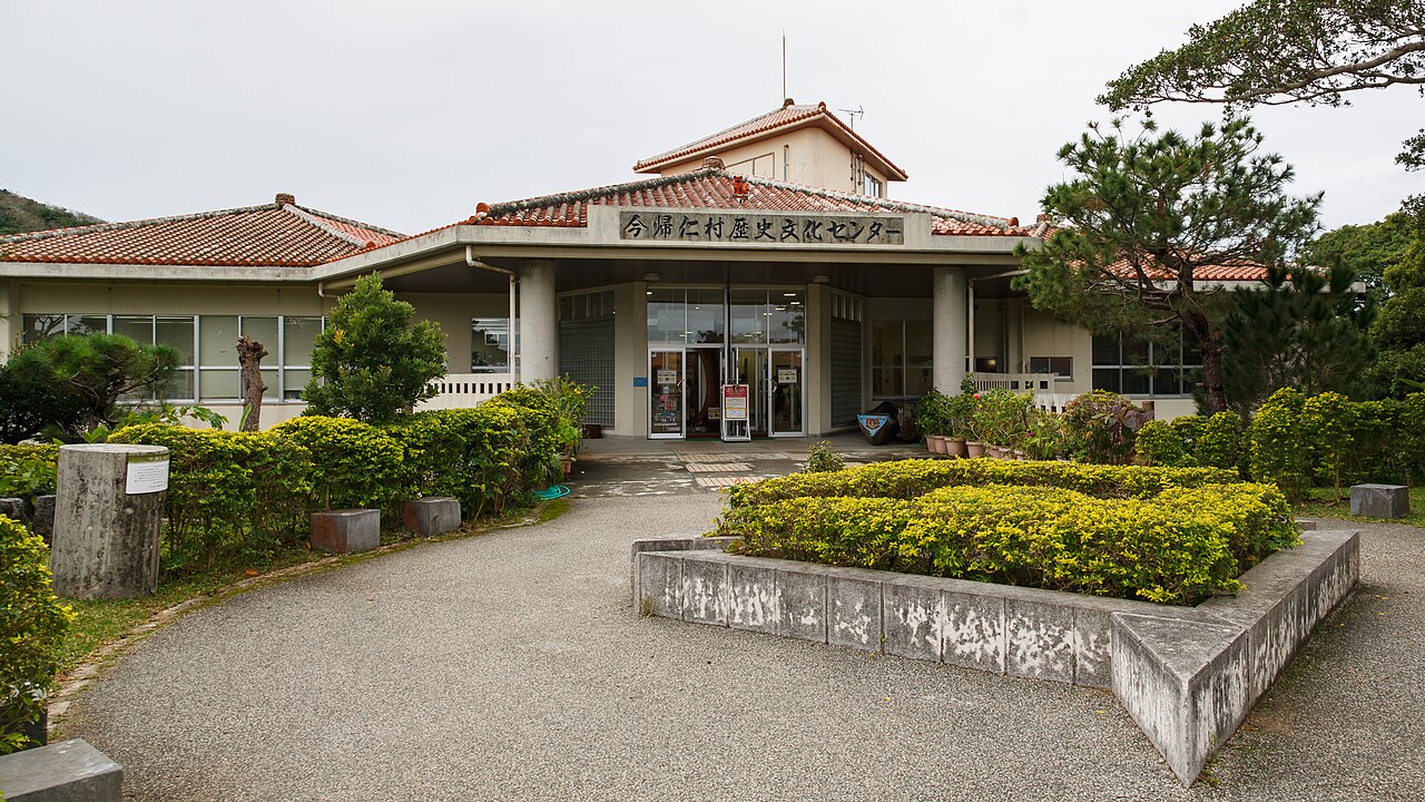 The low red-tiled building of the Nakijin Village Center for History and Culture behind a planted bed