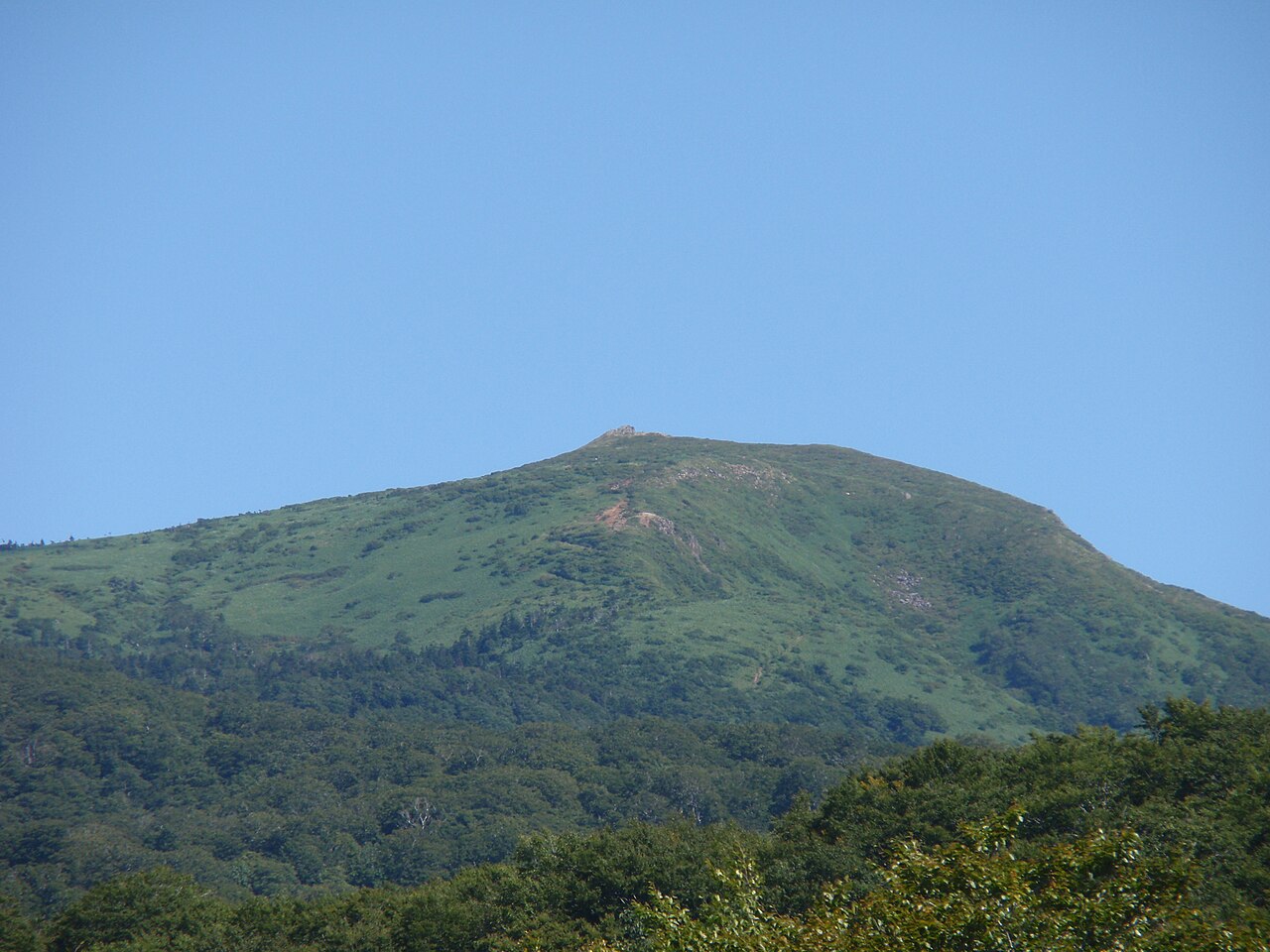 Green summit of Mt. Nyuto seen from Nyuto Onsenkyo under a clear blue sky