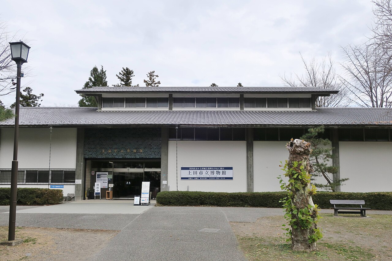 The low tiled entrance of Ueda City Museum with its name sign over the glass doors