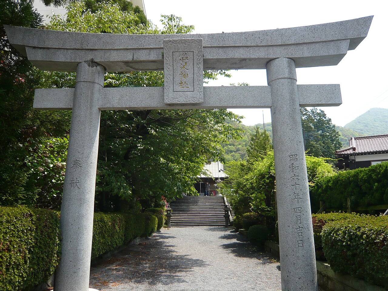 Stone torii and stone steps leading up to Unzen Onsen Shrine among trees