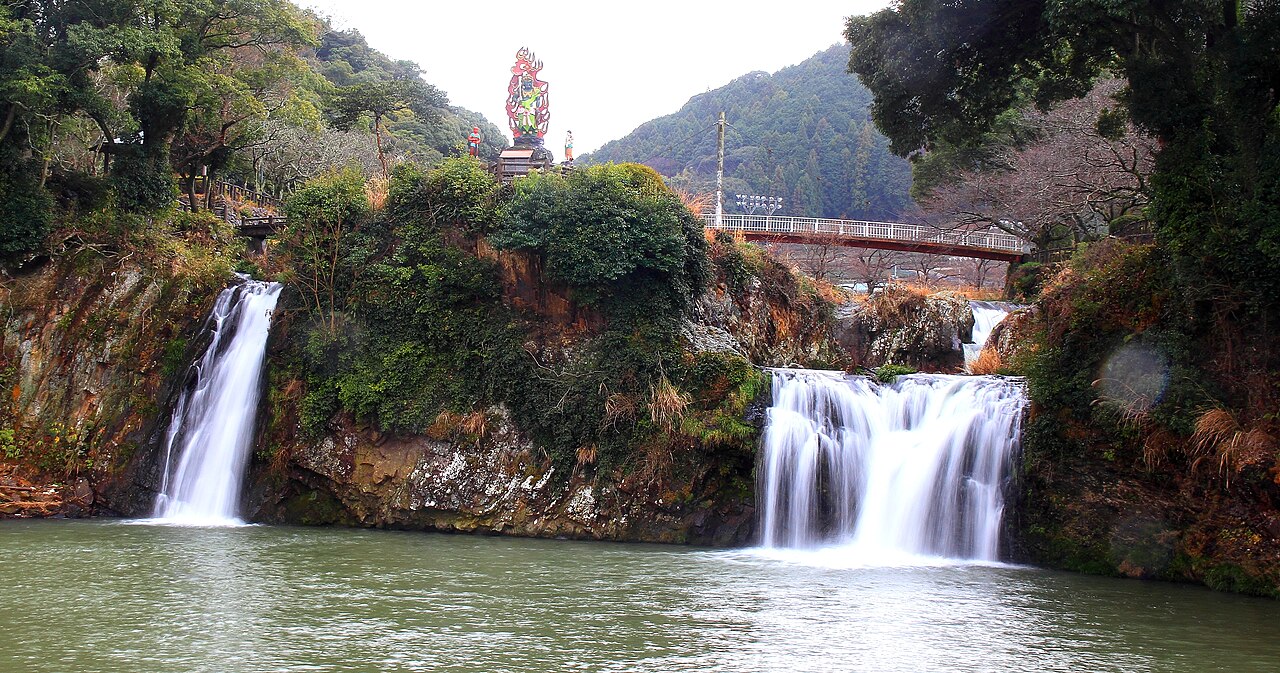 Todoroki Falls in Ureshino, two white cascades pouring into a green pool below a wooded hillside