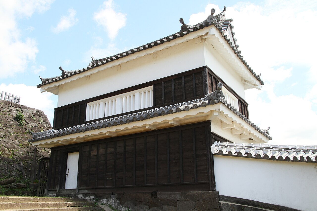 A whitewashed corner turret standing on stone ramparts at the former Usuki Castle grounds