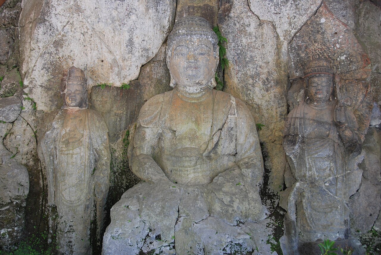 Carved stone Buddha figures set into a rock face at the Usuki Magaibutsu site in Oita