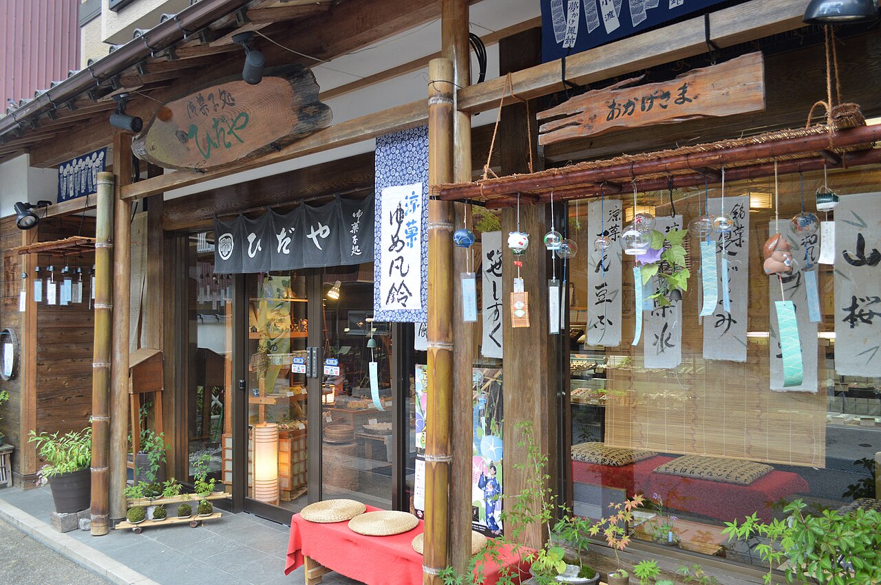 A traditional Japanese sweets shop storefront hung with wind chimes and seasonal decorations.
